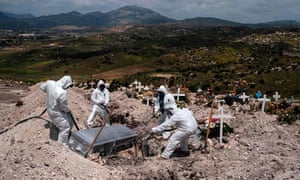 Muncitorii cimitirului care poartă echipament de protecție îngropă victima coronavirusului în Tijuana.