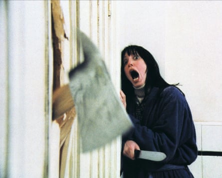 Shelley Duvall as Wendy holds a knife and screams as an axe bursts through a door