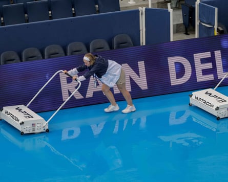 Grounds crews sweep rain off the court during a weather delay at the Cincinnati Open.