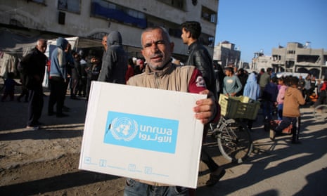 A Palestinian man carries an aid box provided by Unrwa in Khan Younis in the southern Gaza Strip.