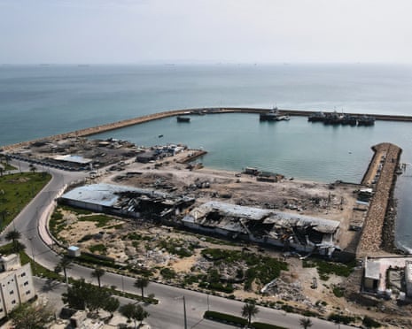 Backdropped by ships in the strait of Hormuz, a fishing pier with damage witnesses say was caused during US-Israeli strikes in the port of Qeshm island, Iran