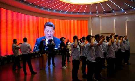 People recite the Communist party oath in front of a screen dominated by an image of Chinese president Xi Jinping.