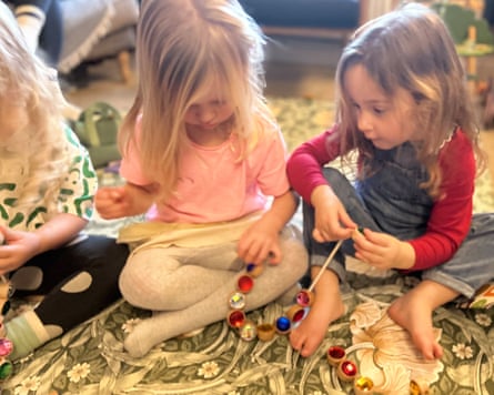Two children playing with the Tickit wooden lacing jewels