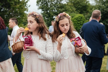 Twin bridesmaids eating crisps at a wedding