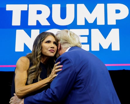 Noem listens as Trump embraces her and speaks into her ear