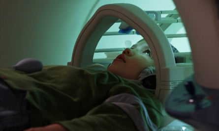 A child enters a mini MRI machine for a brain scan.