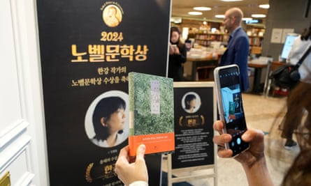 A visitor takes a commemorative photo after buying a book by Han Kang at a bookstore in Seoul, South Korea.