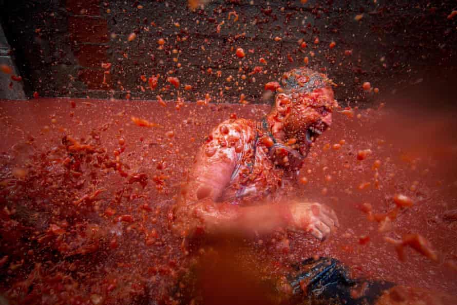 A reveller is pelted with tomato pulp during the annual Tomatina festivities in the village of Buñol, near Valencia.