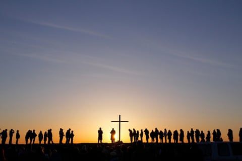  People silhouetted as the sun rises during a dawn service to celebrate Easter Sunday. 