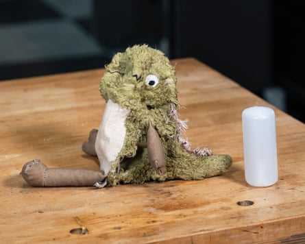 a dinosaur dog toy on a wooden table after a dog has chewed it
