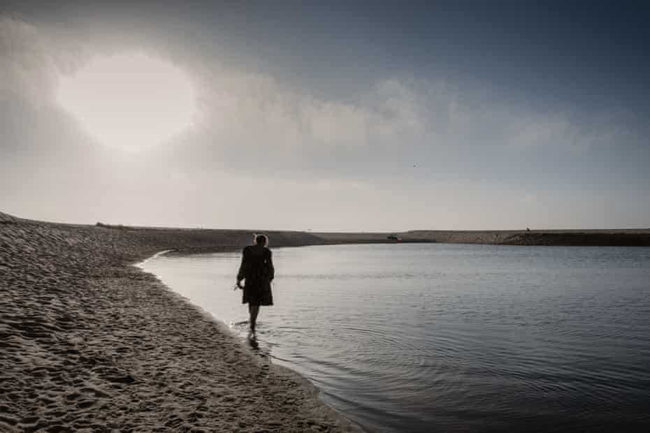 Lily is walking along the shore of Lake Melides in Portugal.
