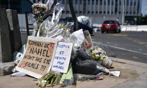 People lay flowers and banners in memory of Nahel near where he was killed in Nanterre