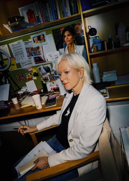 A woman with platinum blond hair sits in a dressing room