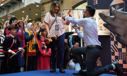 A man proposes to his partner at King's Cross station