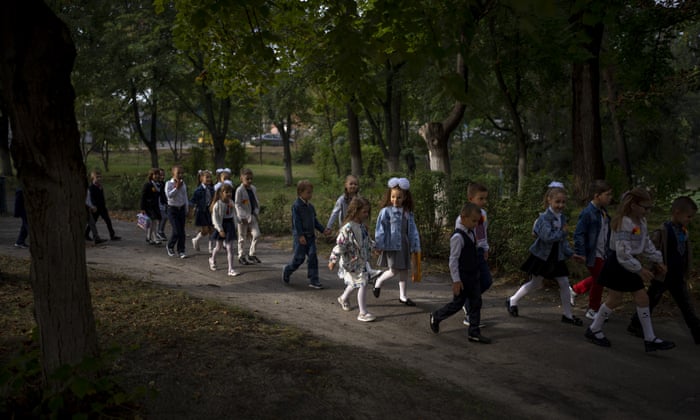 Öğrenciler, Irpin'deki okulun ilk günlerinde sınıfa girerken birlikte yürürler.