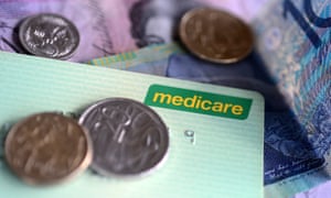 Bank notes and coins are seen with a Medicare card.