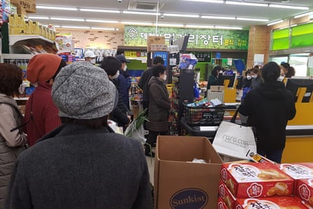 People line up to buy foods and supplies at a supermarket in Daegu, South Korea, on Friday