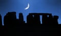 A crescent moon over the silhouette of Stonehenge at night