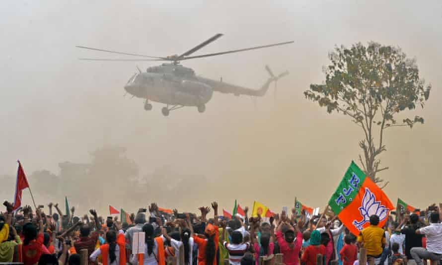 Supporters wave towards a helicopter carrying the Indian prime minister, Narendra Modi, at a rally for West Bengal’s state legislative assembly elections, at Kawakhali on the outskirts of Siliguri, on April 10