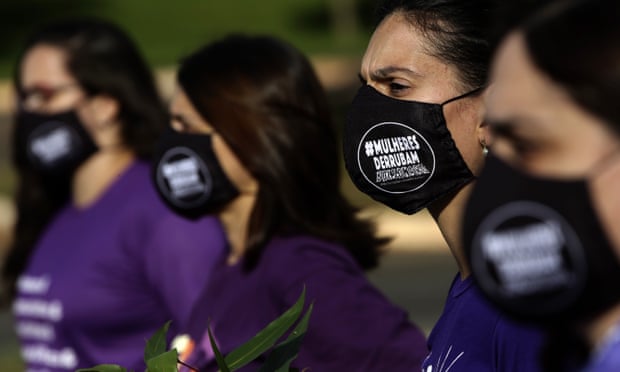 Women wear masks with the phrase ‘women overthrow Bolsonaro’ written on them, during a protest against the government’s inefficiency over the pandemic, in Brasilia, Brazil.
