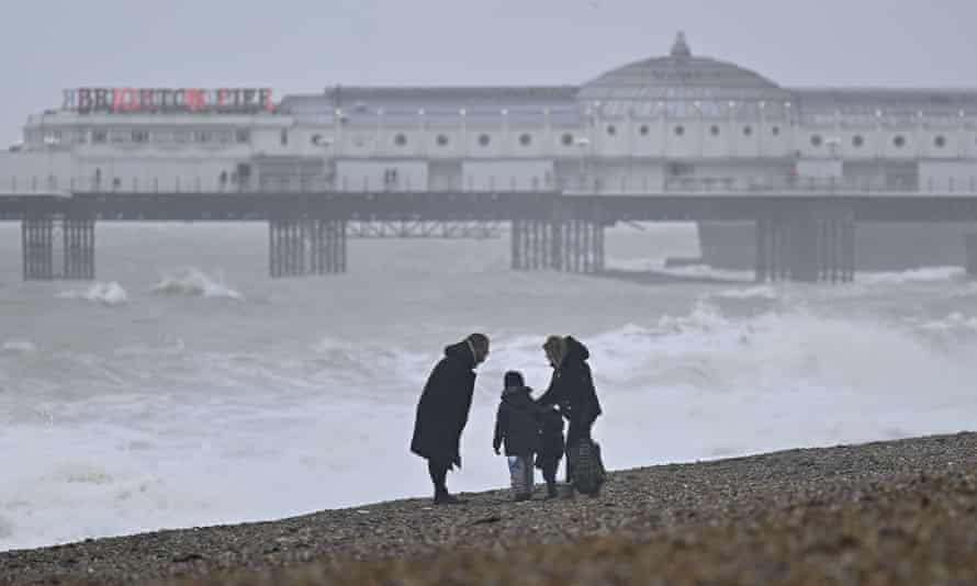 A family on Brighton beach during Storm Dudley.
