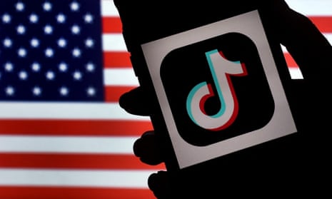 The TikTok logo on a mobile phone, with the US flag behind