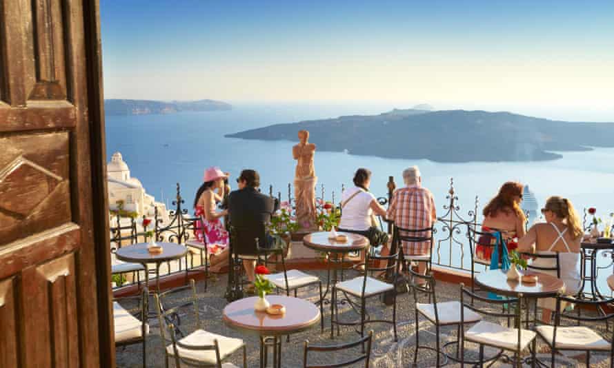 Thira (capital of Santorini) - tourists resting on the greek cafe restaurant terrace, Santorini Island, Greece