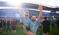 Two City fans celebrate on the pitch after their team secured a fourth title in a row.