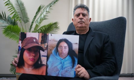 Eli Albag segurando duas fotos de sua filha