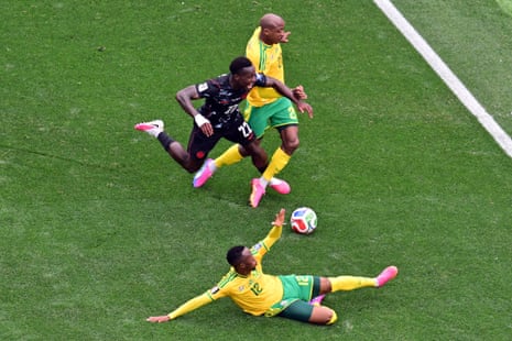 Canada’s defender Richie Laryea fallsunder a challenge from South Africa’s defender Khuliso Mudau.