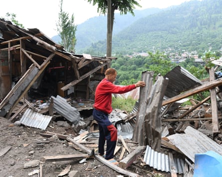 A man removes debris from his wrecked house