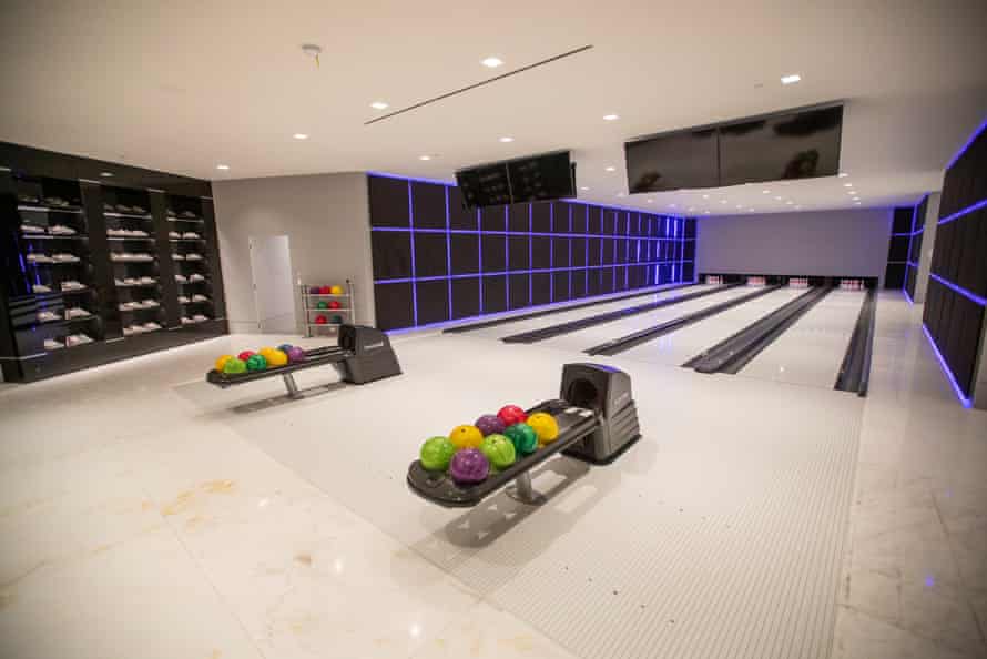 A private bowling alley features four lanes and a wall of bowling shoes.