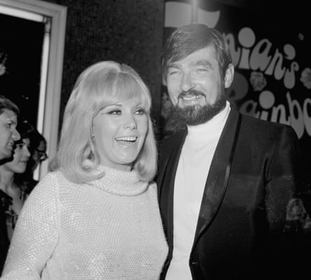 A black and white photo of a couple smiling at an event.