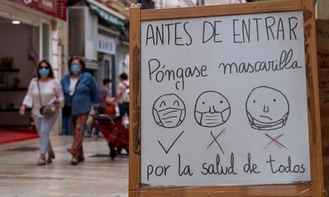 A white board explains how to wear face masks correctly at the entrance to a shop in Huelva, Spain.