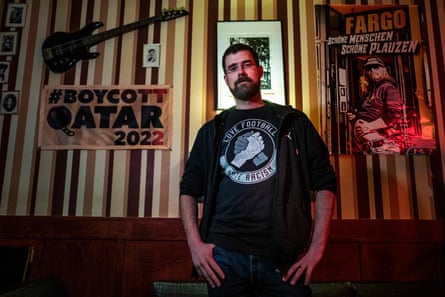 Joschik Pech, passionné de football et porte-parole du bar Fargo, pose à côté d'une bannière