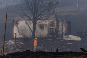 A member of a search and rescue team looks at an area destroyed by the fire