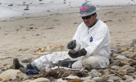 A worker cleans oil contamination one rock at a time in areas affected by an oil spill at Refugio state beach.
