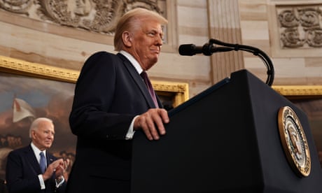 a man in a suit smiles behind a podium