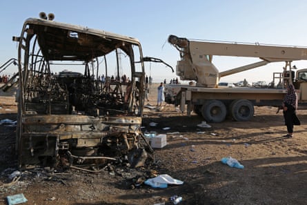 A crane prepares to tow the wreckage of the bus