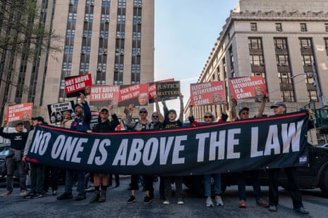 a line of people hold a giant banner that says no one is above the law