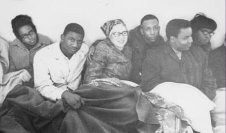 black and white photo of people sitting together covered in blankets
