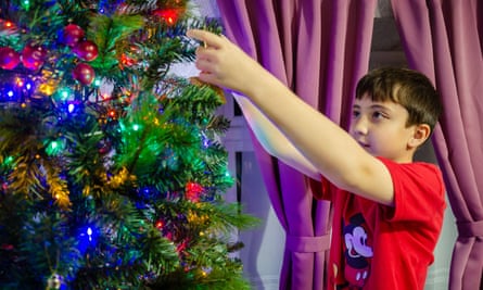 Boy decorates Christmas tree