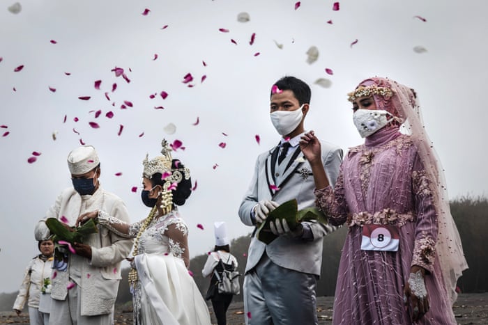 Couples sow flowers as they attend a mass wedding to commemorate the 75th Indonesia’s National Independence Day at Cemara Sewu beach amid the coronavirus pandemic in Yogyakarta, Indonesia.