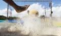 Foot kicking foam buoy towards a football goal in a cloud of dust