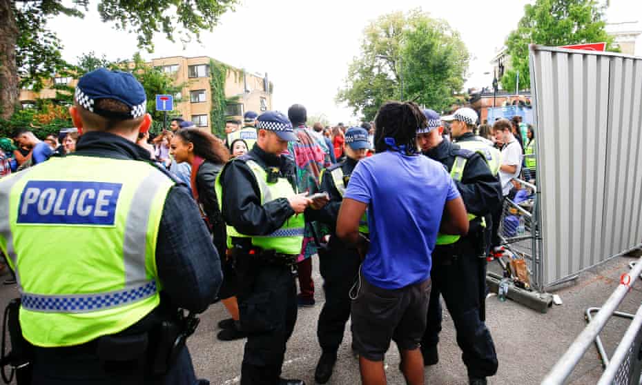 Police stop and search people during the Notting Hill Carnival.