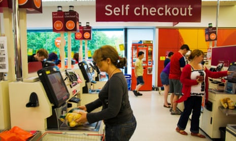 Customers using self service checkout at Sainsbury's supermarket.
