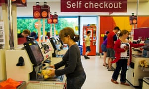 Customers using self-service checkouts at a supermarket