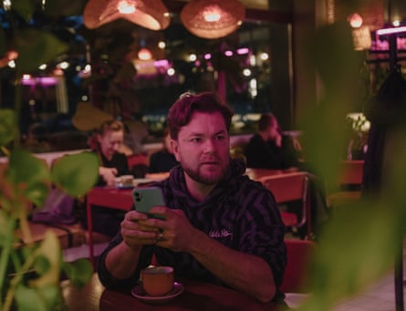 Volodymyr Niankin sitting under lights in a cafe or bar.