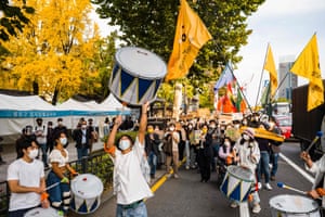 People in the streets bang drums and wave flags