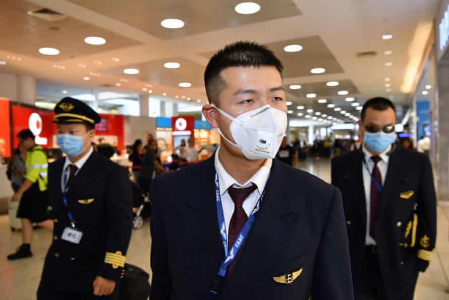 Members of a China Eastern Airlines flight crew wear masks on arrival at Sydney airport on 23 January 2020